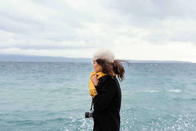 Young beautiful woman in nature with camera