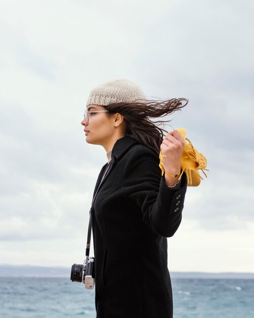 カメラを持つ自然の中で若い美しい女性