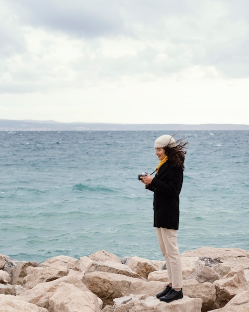 Young beautiful woman in nature with camera