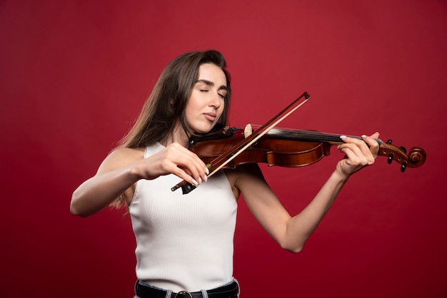 Young beautiful woman playing the violin 