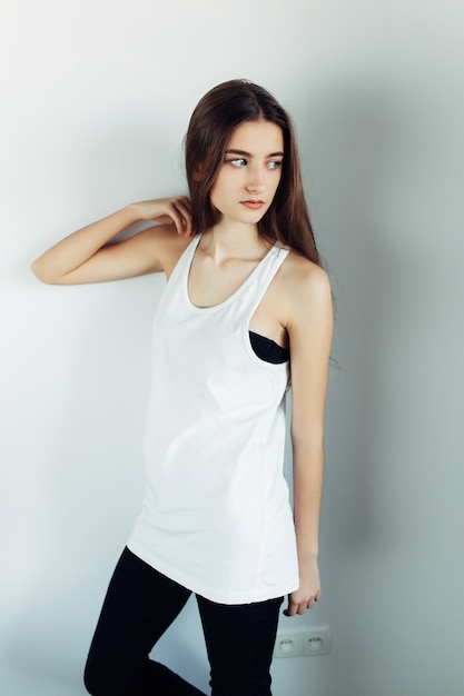 Free photo young beautiful woman posing on a white wall