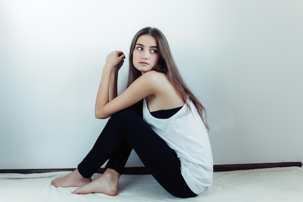 Free photo young beautiful woman posing on a white wall