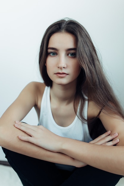 Free photo young beautiful woman posing on a white wall