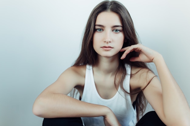 Free photo young beautiful woman posing on a white wall