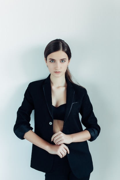 Young beautiful woman posing on a white wall