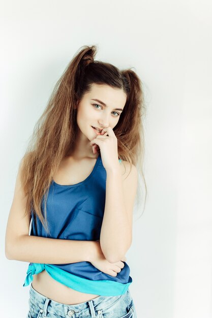 Young beautiful woman posing on a white wall