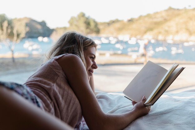 호수 옆에서 책을 읽는 젊은 미녀