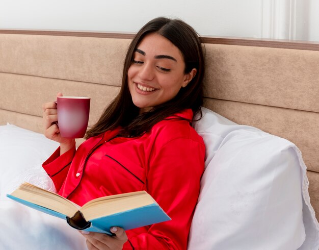 Young beautiful woman in red pajamas relaxing in bed