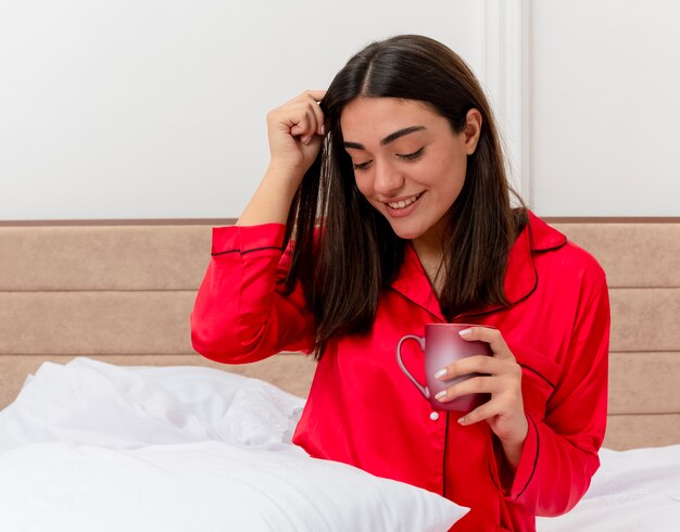 Young beautiful woman in red pajamas relaxing in bed