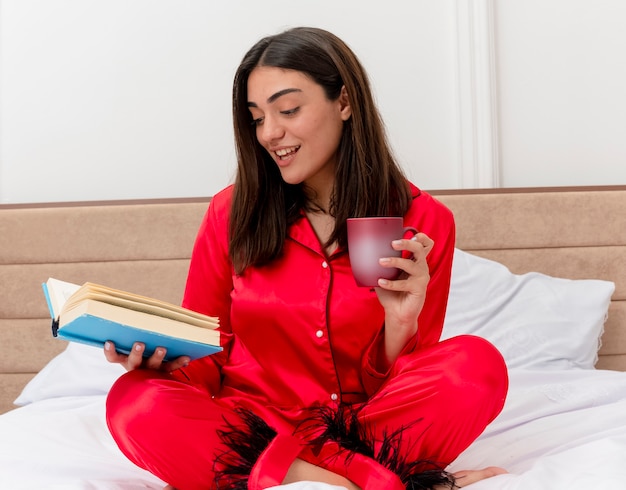 Young beautiful woman in red pajamas relaxing in bed