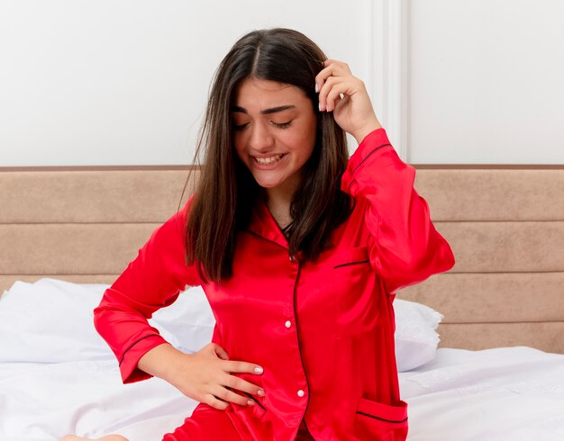 Young beautiful woman in red pajamas relaxing in bed