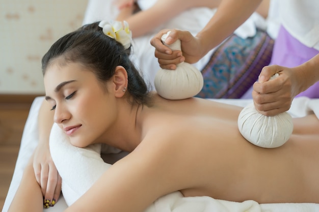 Young beautiful woman relaxing during massage in spa salon.