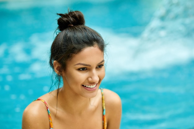 Young beautiful woman relaxing in the pool at wellness center