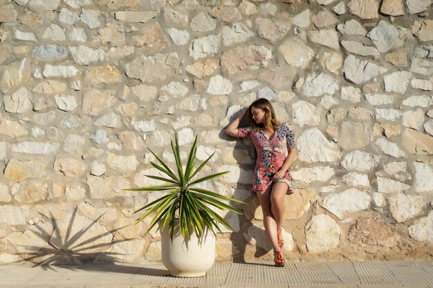 a young beautiful woman in a short dress walks through the streets of a small European town.