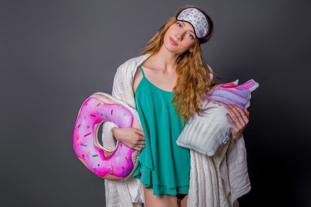 Young beautiful woman in sleepwear with funny pillows