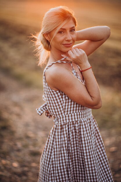 Young beautiful woman on the sunset in field