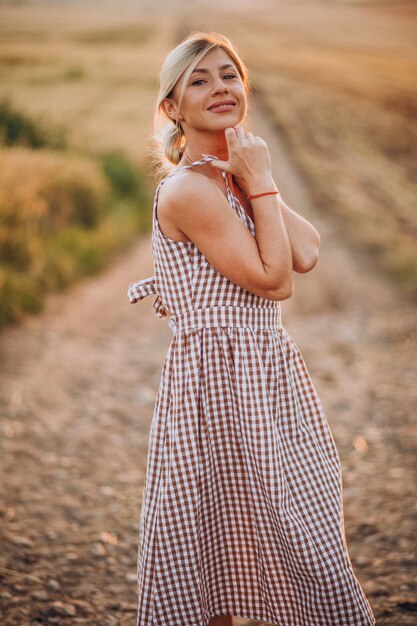 Young beautiful woman on the sunset in field