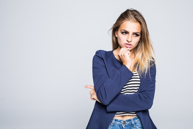 Young beautiful woman thinking looking to the side at blank copy space, isolated