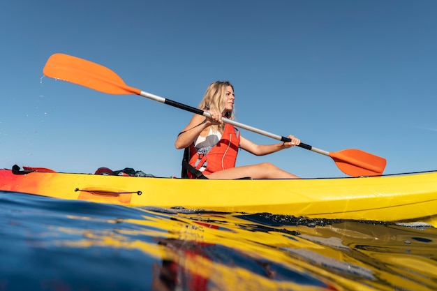 Free photo young beautiful woman traveling by canoe