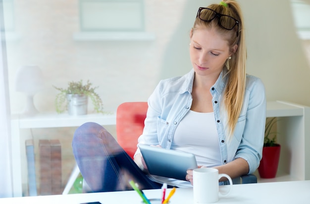 Young beautiful woman using her digital tablet at home.