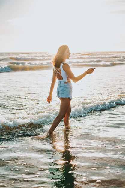 昼間に海辺を歩く若い美しい女性