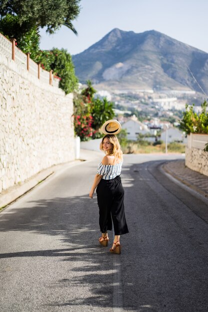 a young beautiful woman walks through the streets of a small European town. summer vacation