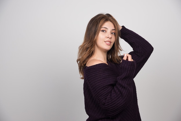 Young beautiful woman in warm knitted sweater standing and posing.