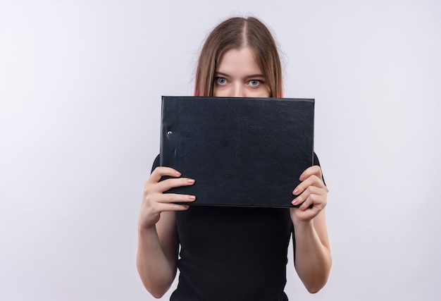  young beautiful woman wearing black t-shirt covered face with clipboard on isolated white wall