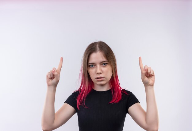  young beautiful woman wearing black t-shirt points fingers to up on isolated white wall with copy space