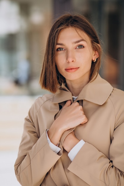 Foto gratuita cappotto da portare della giovane bella donna che cammina nella città