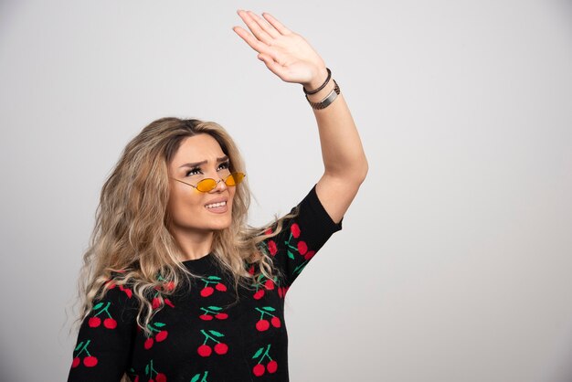 Young beautiful woman wearing glasses showing hand up . 