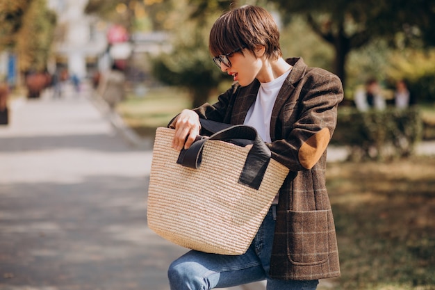 Free photo young beautiful woman with bag outside the street