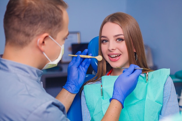 Young beautiful woman with beautiful white teeth sitting on a dental chair.