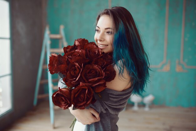 バラの花束を持つ若くて美しい女性