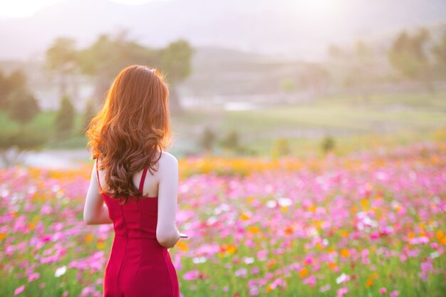 Young beautiful woman with a Cosmos flower.