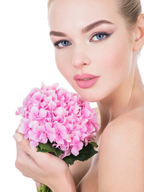 Young beautiful woman with flowers near face.