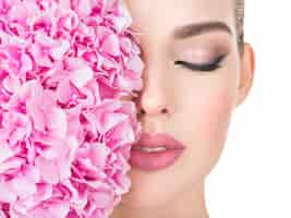 Free photo young beautiful woman with flowers near face.