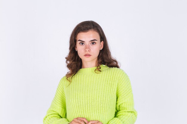 Young beautiful woman with freckles light makeup on white wall posing