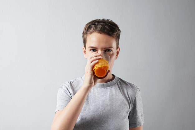 Young beautiful woman with healthly perfect skin dreamly drinking her fresh organic carrot orange juice