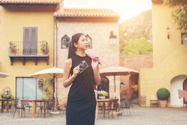 Giovane donna bellissima con fotocamera retrò, stile retrò vintage come