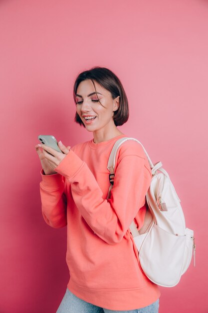 Young beautiful woman with smartphone. Smiling student girl going on a travel.