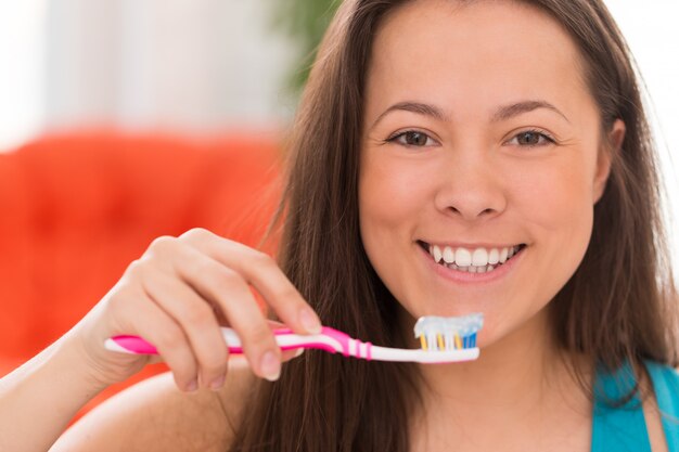 歯ブラシを持つ若い美しい女性
