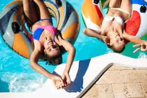 Free photo young beautiful women smiling, sunbathing, relaxing, swimming in pool