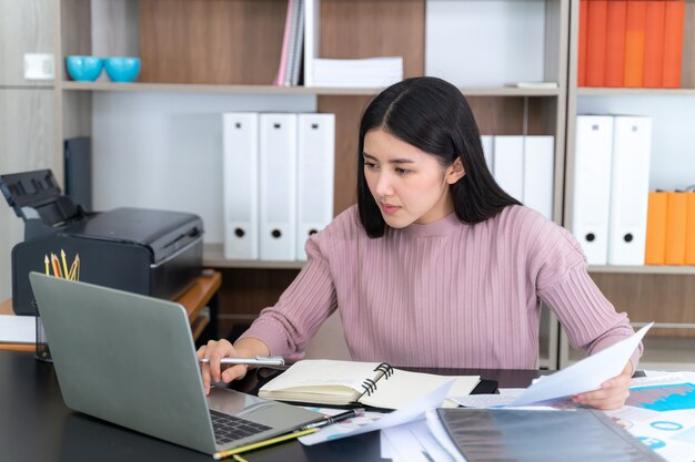 Young beautiful working with laptop on table in office