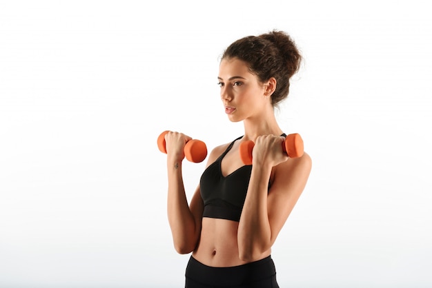 Young beauty fitness woman doing exercise with dumbbells