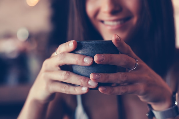 カフェ、屋外で幸せな肖像画でコーヒーを飲む若い美しさの女性