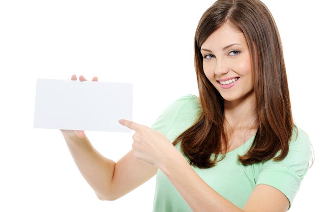 Молодая красавица женщина, указывая на пустую белую карточку - изолированные на белом