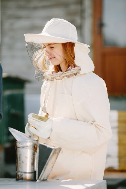 Free photo young beekeeper learning from her teacher. curious woman in coverall.