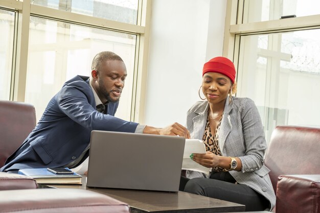 Молодой черный бизнесмен и женщина вместе просматривают документы
