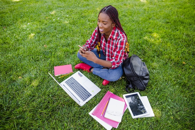 Foto gratuita giovane ragazza nera in posa con i gadget